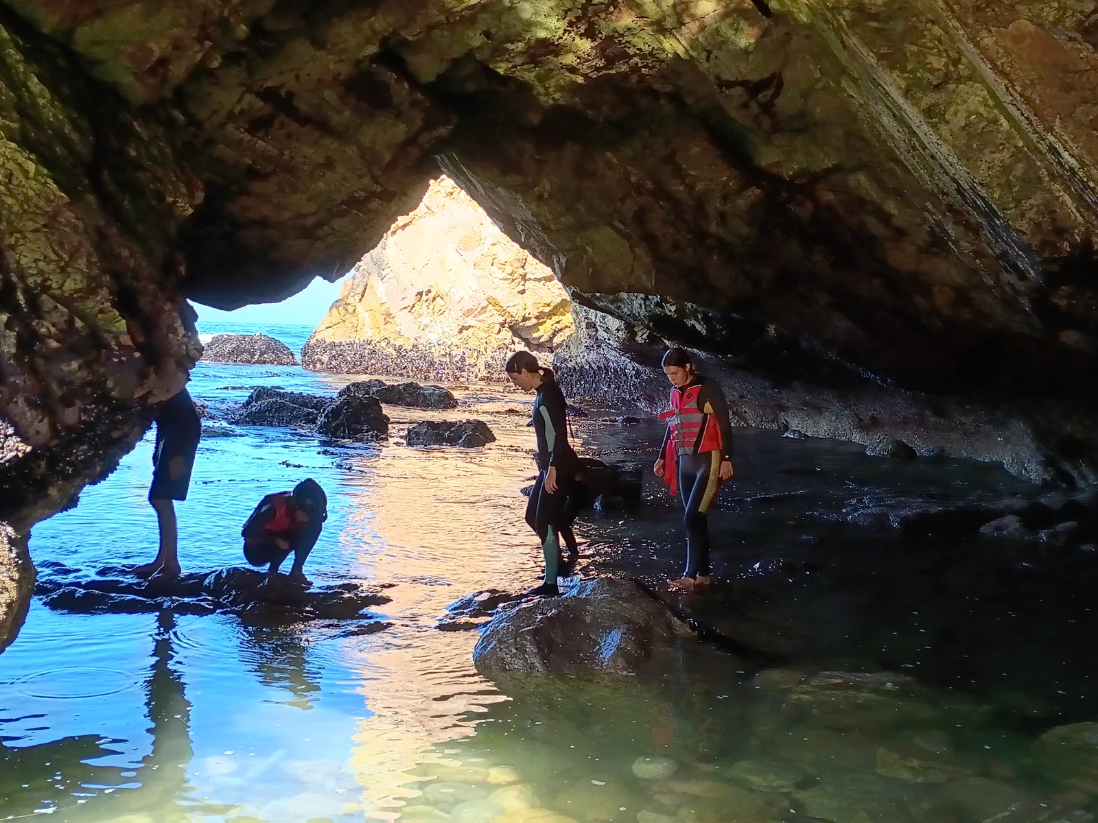 Guests exploring a sea cave on a kayak tour
