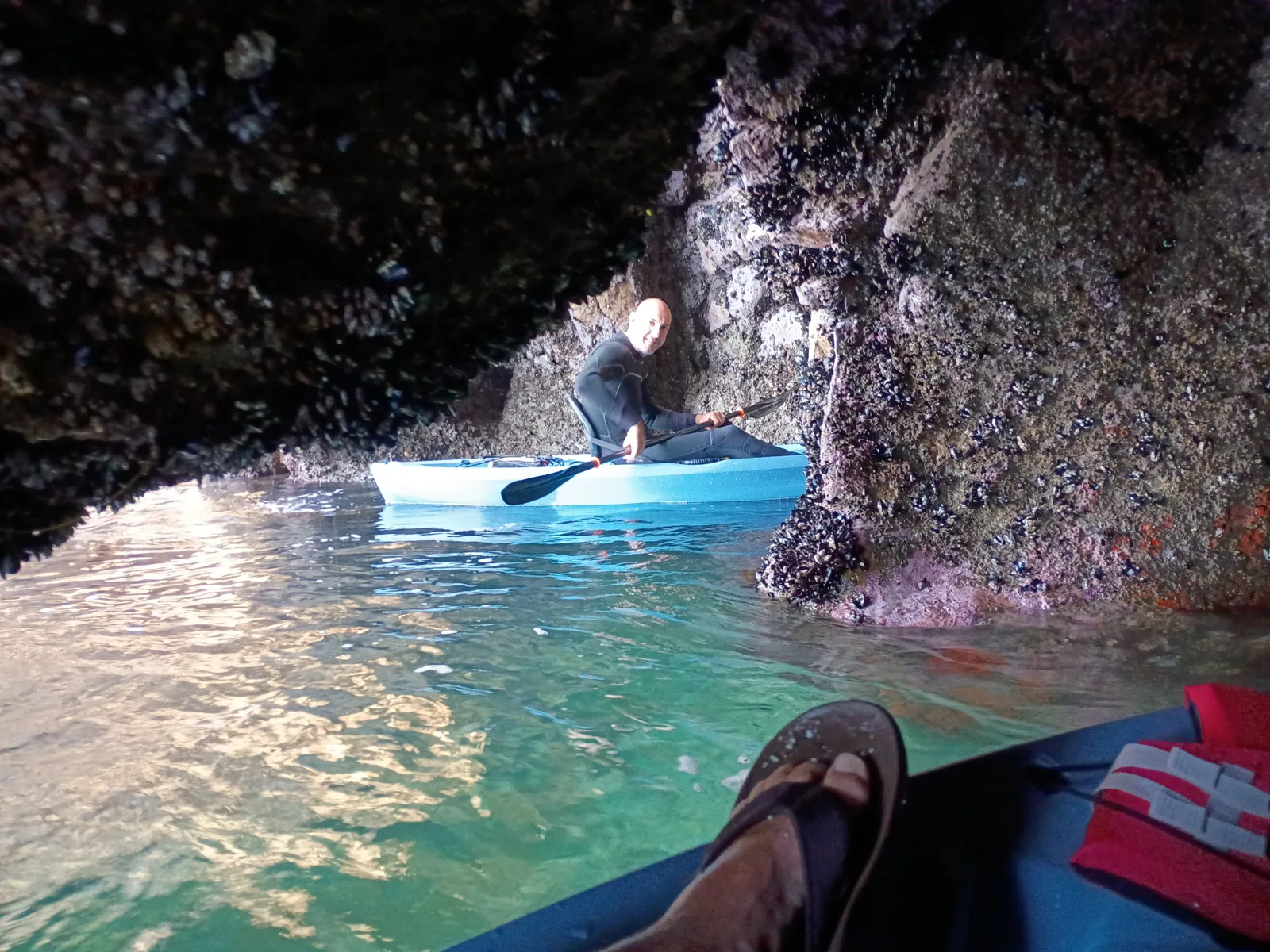 Kayaker gliding through a sea cave at the Dinosaur Caves