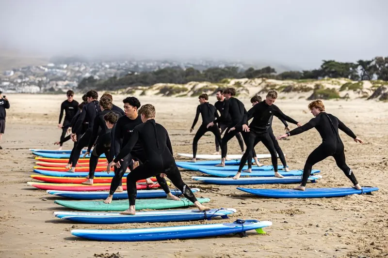 A group surf lesson on the beach with Central Coast Surf School